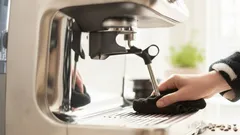 Espressokeittimen puhdistus mustalla liinalla keittiössä
